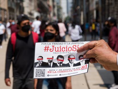 Un hombre entrega propaganda sobre la consulta para enjuiciar a los expresidentes en el centro de Ciudad de México, el 4 de julio.