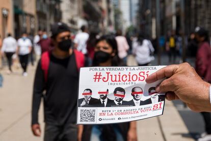 Un hombre entrega propaganda sobre la consulta para enjuiciar a los expresidentes en el centro de Ciudad de México, el 4 de julio.