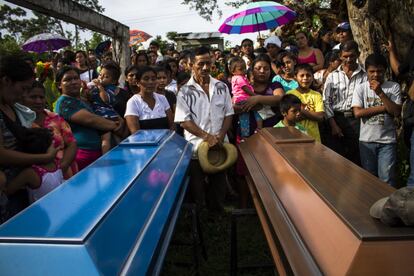 Familiares y amigos de los estudiantes asesinados por una rencilla entre pandillas están de pie mientras se oficia el funeral. Ambos fueron asesinados por la pandilla de la MS. Según un informe publicado en 2013 por la Oficina de las Naciones Unidas contra la Droga y el Delito, hay cerca de 600.000 armas de fuego en El Salvador, 120.000 pertenecen a policías y militares, más de 200.000 están en manos de civiles y el resto tiene un estatus ilegal posesión.