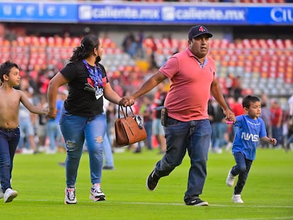 Una familia huye de la violencia en la cancha del Querétaro.