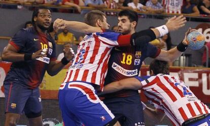 Gurbindo, con el balón, ante Migallón y Aguinagalde, durante el partido de Supercopa entre el Atlético de Madrid y el Barcelona