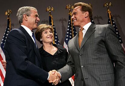 El presidente de EE UU, George Bush, estrecha la mano de Arnold Schwarzenegger ante Laura Bush.