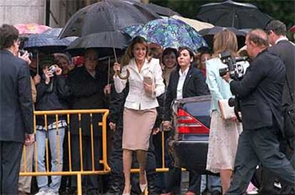Letizia Ortiz se protege de la lluvia a su llegada al Ayuntamiento de Madrid, donde el Príncipe recibió la medalla de oro de la ciudad.