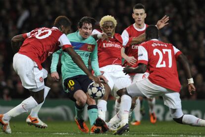 Leo Messi fights for the ball in a sea of Arsenal shirts.