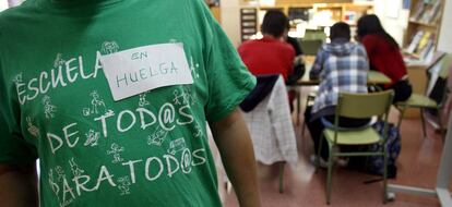 Isidro Álvarez, el dueño del taller de Vallecas (Madrid) donde se inventaron las camisetas de la marea verde, posa con una. 