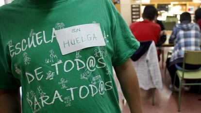 Isidro Álvarez, el dueño del taller de Vallecas (Madrid) donde se inventaron las camisetas de la marea verde, posa con una. 