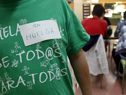 Isidro Álvarez, el dueño del taller de Vallecas (Madrid) donde se inventaron las camisetas de la marea verde, posa con una. 