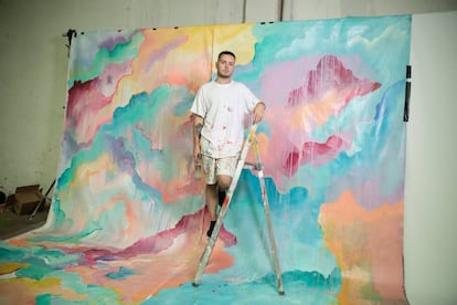 El muralista Mister Piro, en su estudio, posando junto a uno de sus murales.