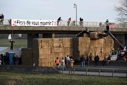 Una pancarta en la que se puede leer "¡Orgullosos de alimentaros!" cerca de un bloqueo de carretera realizado por agricultores en la autopista A4 cerca de Jossigny, al este de París.