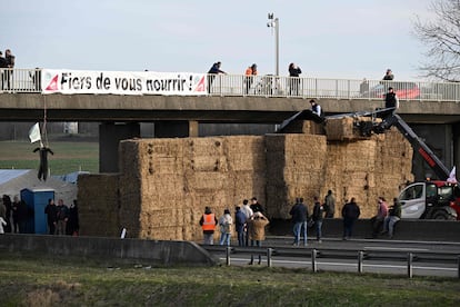 Una pancarta en la que se puede leer "¡Orgullosos de alimentaros!" cerca de un bloqueo de carretera realizado por agricultores en la autopista A4 cerca de Jossigny, al este de París.