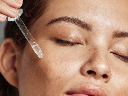 Chica poniéndose un sérum facial.