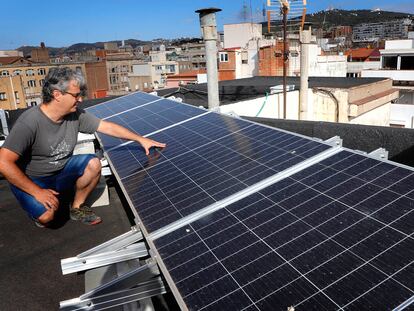 Eduard Moreno, ante los paneles fotovoltaicos que ha instalado en la cubierta del edificio donde vive, en el barrio de Gràcia de Barcelona.