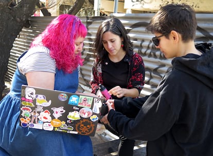 Sharon Ponce de Leon, Daniela Bosh y Belén Carabajal, algunas de las mujeres del movimiento cyberciruja, buscan piezas en aparatos donados a la feria. 