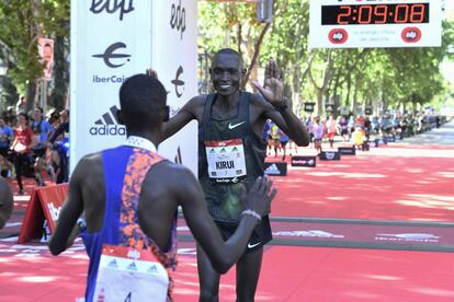 Los atletas kenianos Reuben Kerio (izquierda), ganador, espera en la llegada a Kiprotich Kirui, tercero, tras entrar en meta de la Maratón masculina en el Paseo de la Castellana de Madrid.