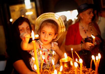 Una niña enciende una vela durante el servicio religioso por el día de la Virgen María en la catedral de Sioni en Tbilisi, Georgia, el 28 de agosto.