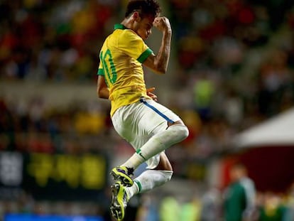 Neymar pula de alegria ao comemorar um gol de falta em amistoso com o Brasil.