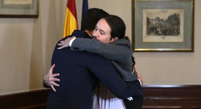 Pedro Sánchez and Pablo Iglesias embrace after signing their agreement on Tuesday.