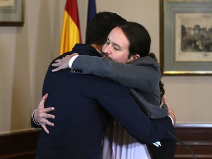 Pedro Sánchez and Pablo Iglesias embrace after signing their agreement on Tuesday.