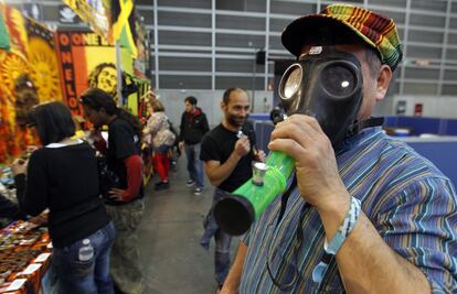 Un visitante se prueba una máscara de gas adaptada para fumar cannabis.