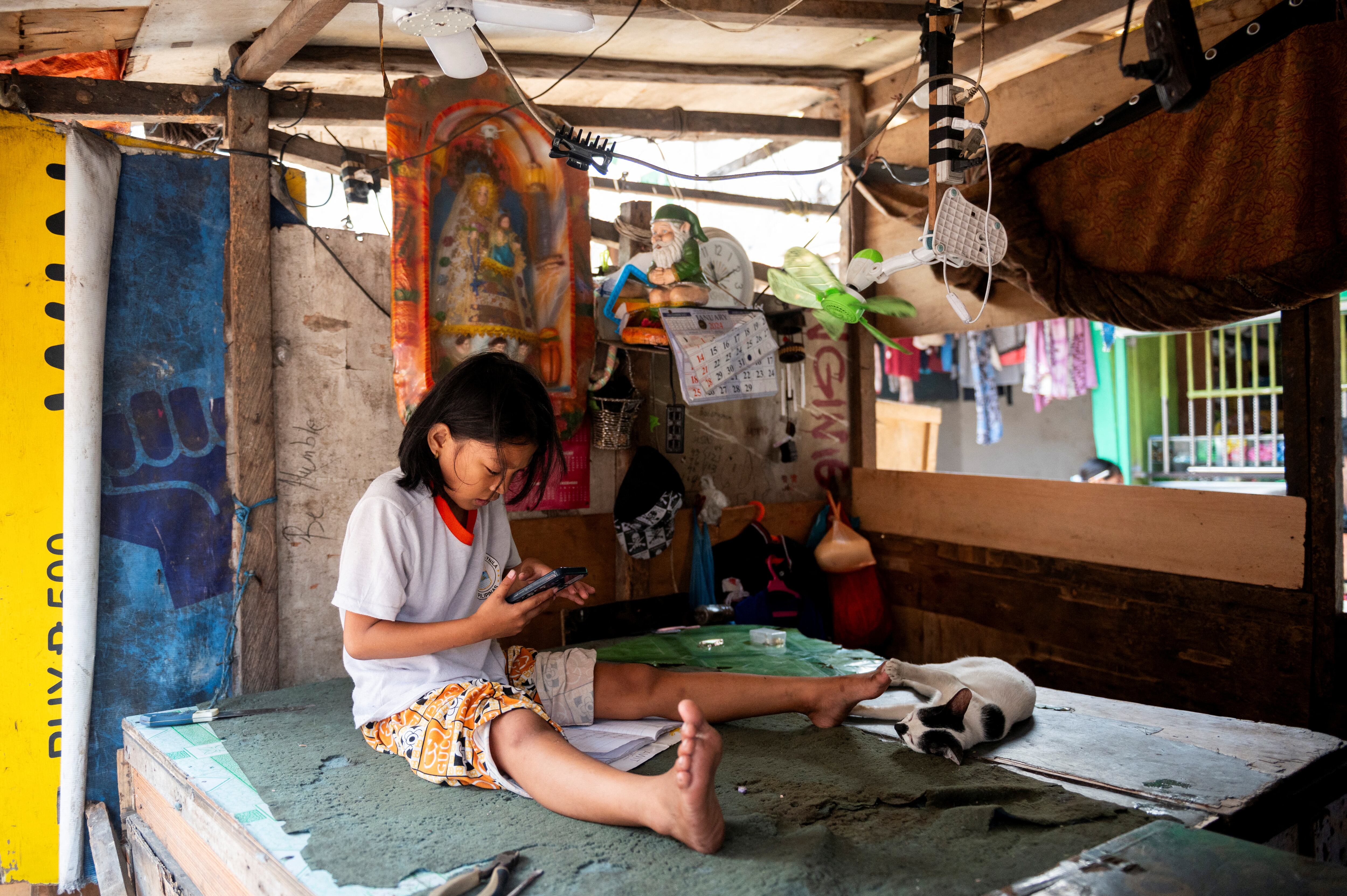 Una niña respondía el viernes a las preguntas de su módulo de aprendizaje en la tienda de sus padres en Manila.