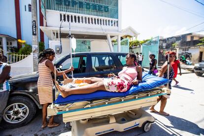 Una mujer herida durante el terremoto recibe ayuda sobre la calle. 