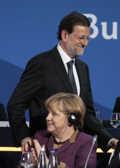 Merkel aplaude a Rajoy tras su intervención.