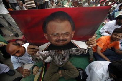 Un seguidor del Movmiento Muttahida Qaumi de Pakistán sostiene una foto de su líder Altaf Hussain en un acto en la sede del partido en Karachi.