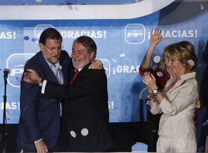 Rajoy y Mayor Oreja se abrazan en la fiesta postelectoral del PP aplaudidos por Esperanza Aguirre.