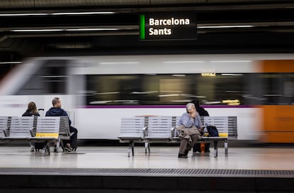 Varios pasajeros esperan un tren en la estación de Sants (Barcelona).