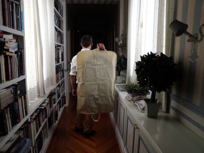 An Ambrosio employee returns a drycleaned suit to a client's home.