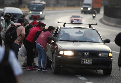 Decenas de personas esperan algún medio de transporte que los traslade a sus trabajos, hoy martes en Lima. 