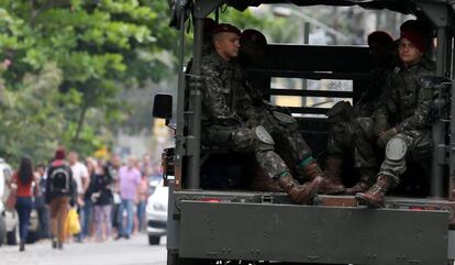 Exército foi convocado no Rio de Janeiro para garantir a segurança durante a votação em bairros, sobretudo na zona oeste, com presença de milícia. Na foto, enquanto os militares fazem a patrulha, pessoas fazem fila em um colégio público para escolher o próximo prefeito da cidade.