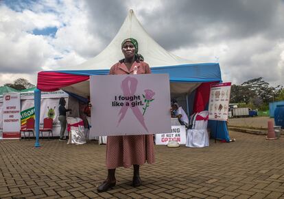 Una mujer sostiene una placa durante una marcha para sensibilizar sobre la importancia de los controles para prevenir el cáncer de mama en Nairobi, Kenia.