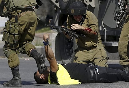 Un joven palestino yace en el suelo mientras sostiene el cuchillo con el que acaba de apu?alar a un soldado israel, tras ser abatido en la ciudad palestina de Hebrn, este viernes, 16 de octubre de 2015. El asaltante palestino se disfraz de fotgrafo de prensa y atac al soldado, hirindole de forma moderada. Fuerzas en el lugar respondieron a la amenaza y dispararon al atacante, lo que result en su muerte, segn informaron fuentes del Ejrcito israel.