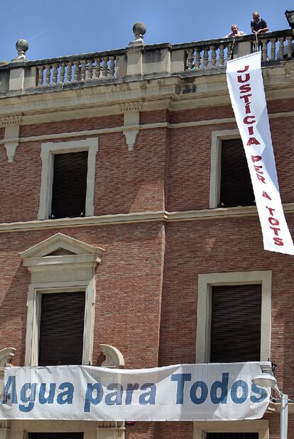 Militantes socialistas colocan la pancarta en la Diputación de Castellón.