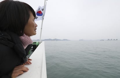 Una mujer, familiar de una de las víctimas del hundimiento del ferri Sewol, llora mientras observa las operaciones de remolque del barco, cerca de Jindo (Corea del Sur).