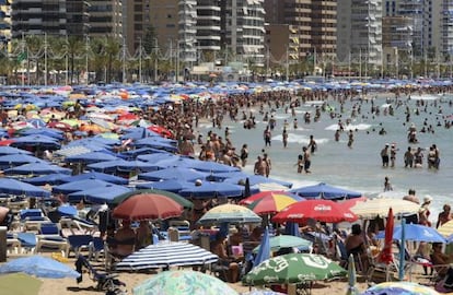 Miles de turistas abarrotan la playa de Levante de Benidorm (Alicante)