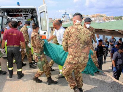 Fotografía facilitada por la Armada de Italia que muestra a varias personas que trasladan el cuerpo de uno de los 94 inmigrantes muertos tras el naufragio de una barcaza que intentaba llegar a la isla de Lampedusa, en el puerto de Lampedusa (Italia).