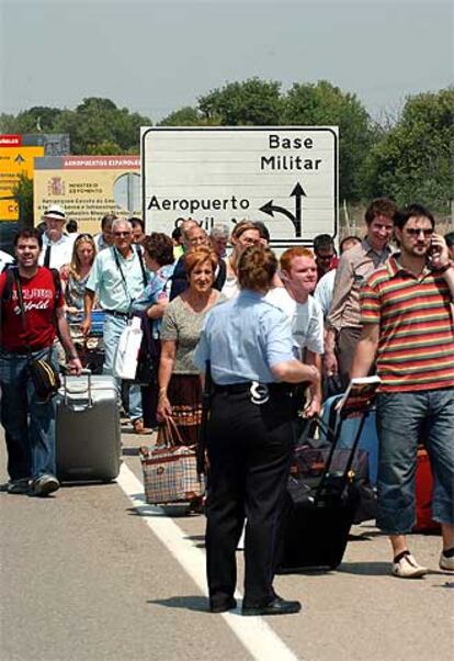 Una policía junto a los viajeros desalojados del aeropuerto de Zaragoza.