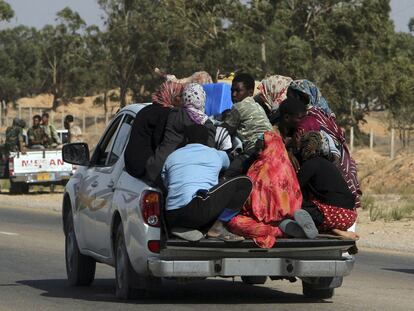 Un grupo de refugiados huye de Sirte por los enfrentamientos entre rebeldes y gadafistas.