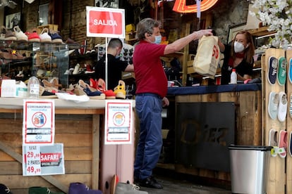 Un cliente compra en una tienda del centro de Madrid este lunes, tras la reapertura del pequeño comercio.