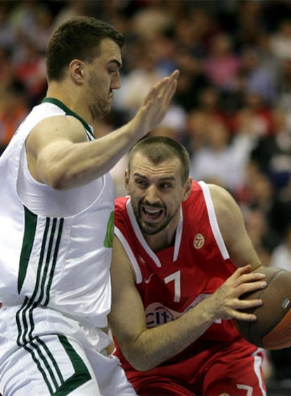 El jugador del Olympiakos Piraeus Nikola Vujcic avanza hacia la cesta con el bloqueo de Nikola Pekovic del Panathinaikos.