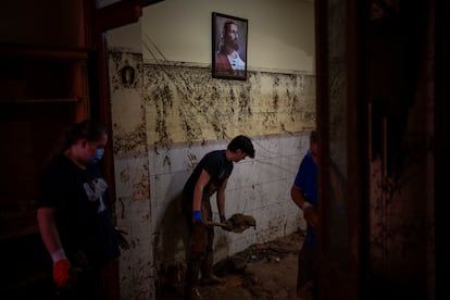 Varios vecinos limpian el interior de una vivienda en Paiporta, el martes.