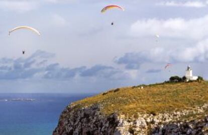 Parapentistas en el cabo del Faro de Santa Pola, con la la isla de Tabarca al fondo (Alicante).