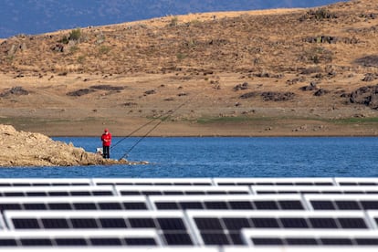 Un hombre pesca cerca de la planta fotovoltaica flotante.
