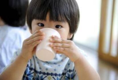 Un niño da un sorbo a un vaso en una guardería. EFE/Archivo