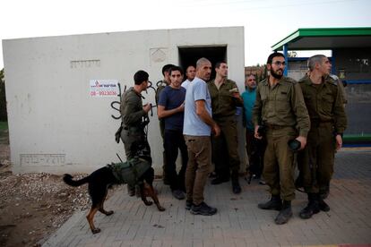 Civiles y militares israelíes permanecen en las afueras de un refugio antiaéreo situado en la frontera entre Israel y Gaza.