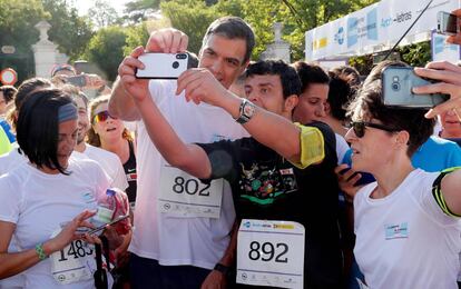 Pedro Sánchez se fotografía con un corredor, este domingo en Madrid.