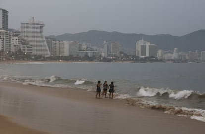 Otis made landfall on the coast of Acapulco shortly before 1 a.m. as a Category 5 hurricane, the highest level on the Saffir-Simpson scale, with maximum sustained winds of 165 mph (260 km/h) and 32-foot (10m) waves. Above, people walking along a beach in Acapulco on the afternoon of October 24, before Otis slammed into the area. 
