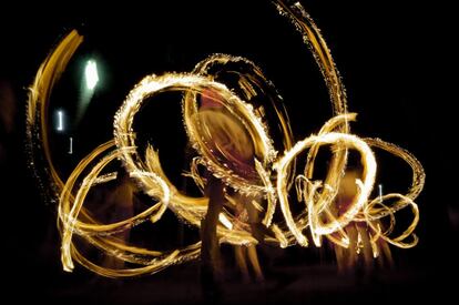 Antorchas en movimiento durante una procesión en un templo budista de Walpola, en las afueras de Colombo (Sri Lanka).